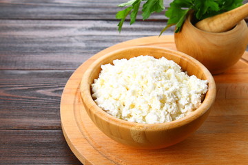 Home cottage cheese in a bowl on a wooden table.