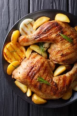 Gardinen Homemade BBQ: Grilled chicken legs with orange, lemon, onions, garlic and potatoes Close-up on a plate. Vertical top view © FomaA
