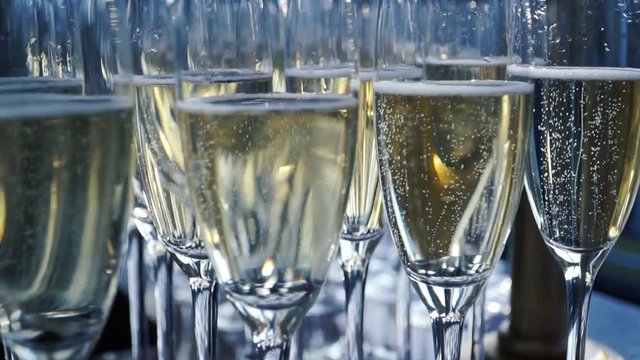 A lot of wine glasses with a cool delicious champagne or white wine at the bar. Alcohol background. Clip
