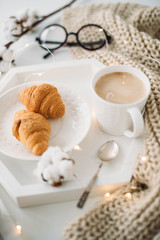 Cozy home breakfast, warm blanket, coffee and croissant on white