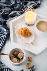 Cozy home breakfast, warm blanket, coffee and croissant on white