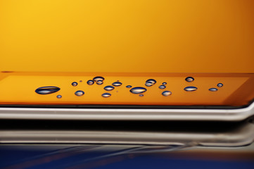 Drops of water on the smartphone screen. A saturated bright colored background. Copy space. close-up