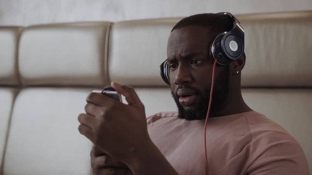 Young african guy is getting serious stearing at his phone