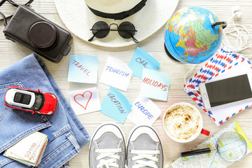Traveler's accessories and items, stickers with notes on white wooden background, planning holidays travel to Europe by car concept.