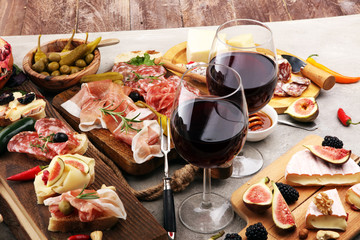 Fototapeta na wymiar Italian antipasti wine snacks set. Cheese variety, Mediterranean olives, pickles, Prosciutto di Parma and salami
