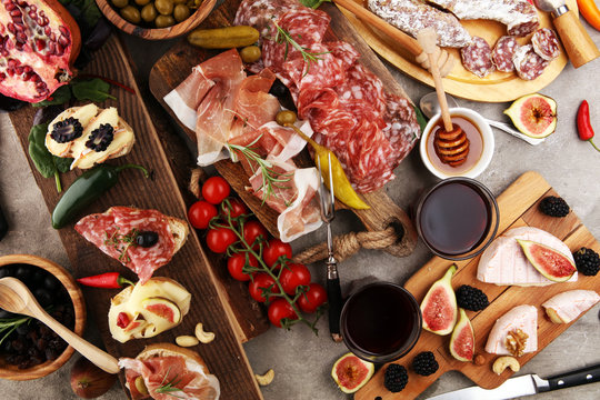 Italian antipasti wine snacks set. Cheese variety, Mediterranean olives, pickles, Prosciutto di Parma and salami