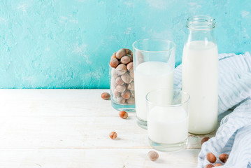 Vegan alternative food, hazelnut non-dairy milk on light blue background, copy space