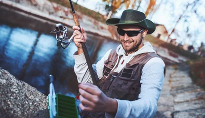 Zelfklevend Fotobehang Fisherman enjoys in fishing on the river. Sport, recreation, lifestyle © bobex73