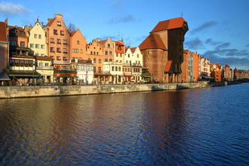 Panoramiczny widok na zabytkową architekturę Gdańska, Wielki Żuraw, historyczne kamieniczki nad rzeką Motławą, słoneczny dzień - obrazy, fototapety, plakaty