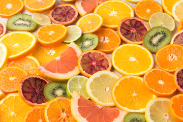 Colourful fruits background oranges, clementines, blood oranges, kiwis and grapefruits on white table, selective focus