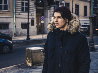 Obraz premium adult long hair man in jacket walking in the europe street on a winter day