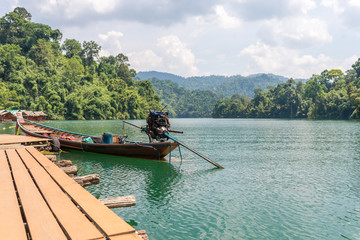 Pier from the raft houses and national park ranger station Klong Pae. The long-tail boat is mooring in front
