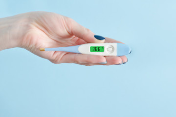 Electronic thermometer in a female hand. Normal temperature. Close up