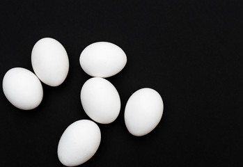 White eggs on the black background. Top view.