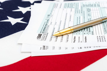 Tax forms with pen on american flag. Business concept.