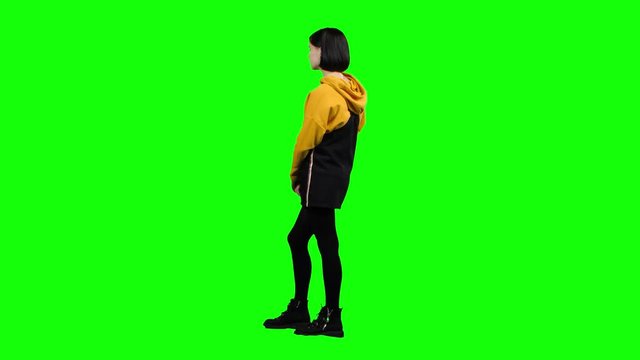 Girl takes offense at her friend, turned away from him. Green screen. Side view