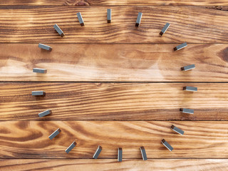 Circle of dominoes, which stay on wooden background. Top view.