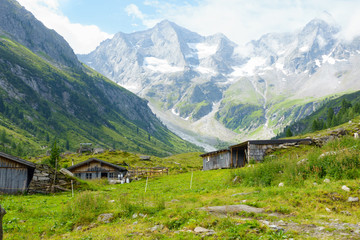 Fototapeta na wymiar Almhütte mit Milchkannen in den Bergen