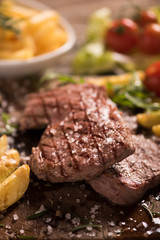 grilled meat with herbs on wooden board