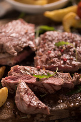 grilled meat with herbs on wooden board