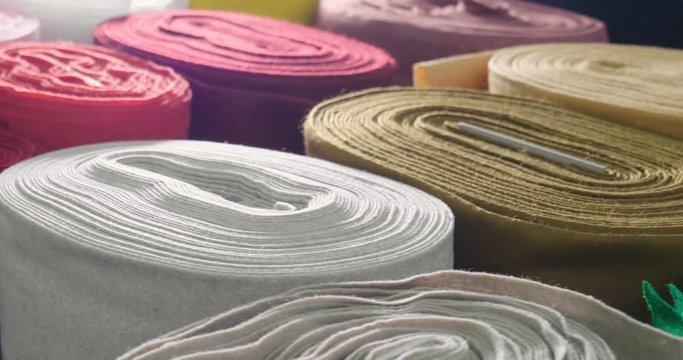 In a textile shop, there are fabrics of various colors and various materials, such as fabric, lace, satin, linen. Concept of: tailoring, colors, fabrics, clothes and fashion.