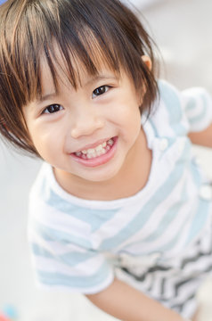 Happy little asian girl smiling play with sand