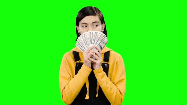 Girl holds paper bills in her hands and rejoices in victory. Green screen