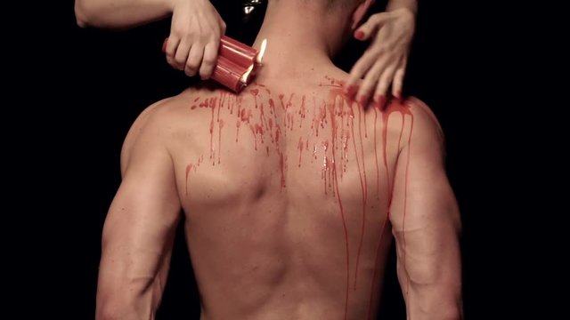 Dripping wax on a male body
