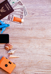 Top view accessories for travel on old wood, Shells, yellow camera ,shoes ,glasses ,necktie ,  hat ,and Dollar on Thailand passport. photo concept travel and life style. 