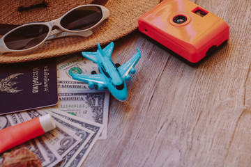Top view accessories for travel on old wood, Shells, yellow camera ,shoes ,glasses ,necktie ,  hat...