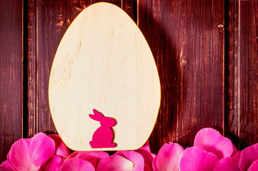Happy Easter mockup. rabbit and egg with rose flowers leaves close-up on wooden background with copy space. easter sale, greeting and celebration card concept.