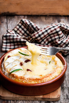 Delicious  hot baked camembert with sultanas on wooden table