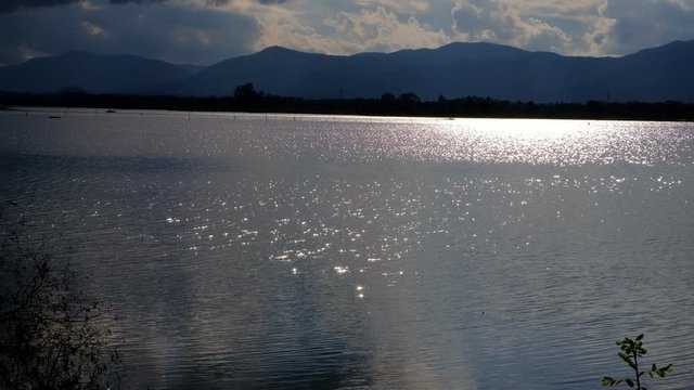 The lake has a reflection of the clouds and the sky. 