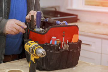 Hand of handyman with a tool bag.