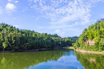 Calm lake and green hills in summer sunlight