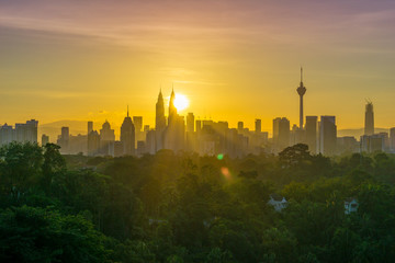 Fototapeta na wymiar Majestic sunrise over Petronas Twin Towers and surrounded buildings in downtown Kuala Lumpur, Malaysia