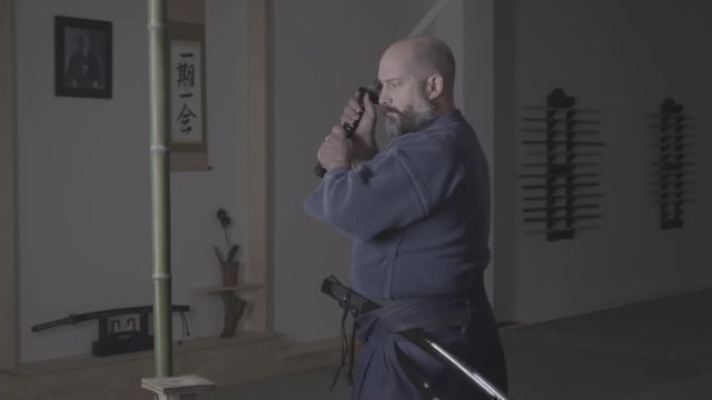 Iaido sensai cuts bamboo with katana