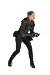 Naklejka premium full length portrait of female soldier wearing black tactical armour, holding a remote control, isolated on white studio background.