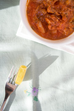 Fork With A Rigatone Pasta And Near A Red Sauce Bowl