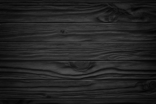 black wooden abstract background with light and scratches, dark wood texture