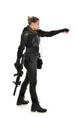 Naklejka premium full length portrait of female soldier wearing black tactical armour, holding a rifle gun, isolated on white studio background.