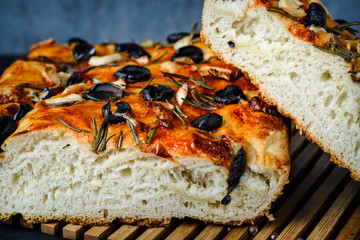 Traditional Italian vegetarian focaccia of homemade bread with olives, rosemary and garlic