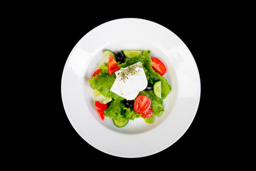 fresh vegetables salad with cheese on black background