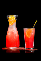 Red lemonade with orange on a black background