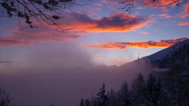  Time lapse shot: Beautiful sunset in the mountains with a natural frame of tree branches, Alps, Bielmonte, Italy