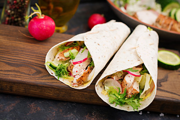Healthy mexican tacos with baked chicken breast, cucumber, radish and lettuce.