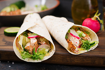 Healthy mexican tacos with baked chicken breast, cucumber, radish and lettuce.