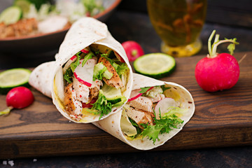 Healthy mexican tacos with baked chicken breast, cucumber, radish and lettuce.