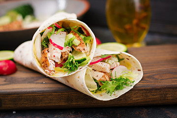 Healthy mexican tacos with baked chicken breast, cucumber, radish and lettuce.