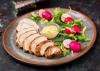 Baked chicken breast and fresh vegetables on the plate on a dark background. Proper nutrition. Dietary menu.
